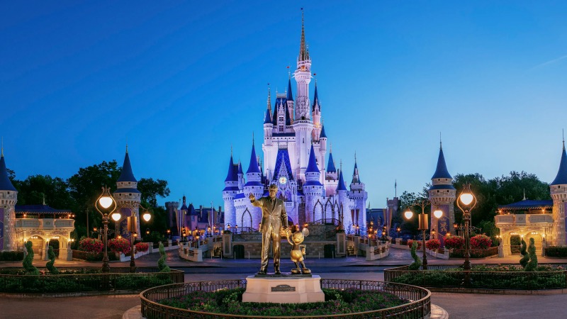 Castelo da Cinderela e Estátua de Walt Disney ao anoitecer no Magic Kingdom da Disney Orlando